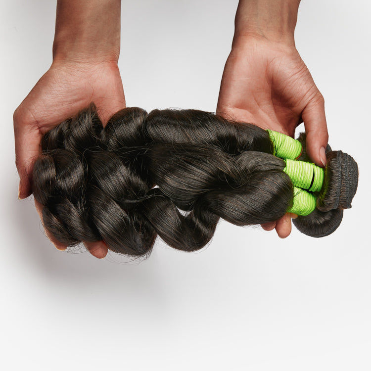Three loose wave human hair bundles from Luvme, 100% virgin natural hair with a soft, flowing wave pattern.